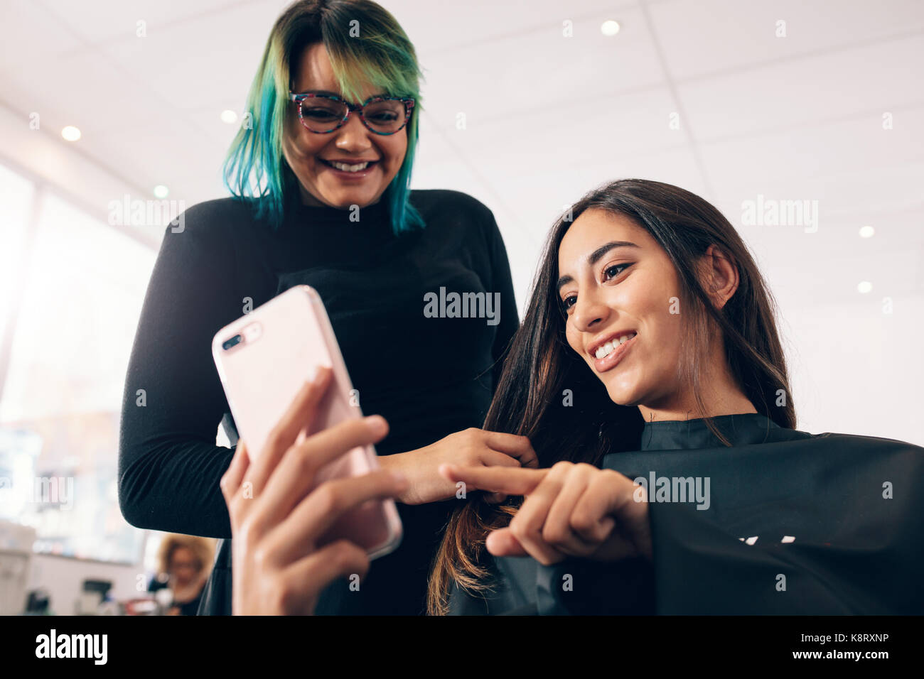 Hair Stylist In Colorful Hairstyle Looking At Mobile Phone While
