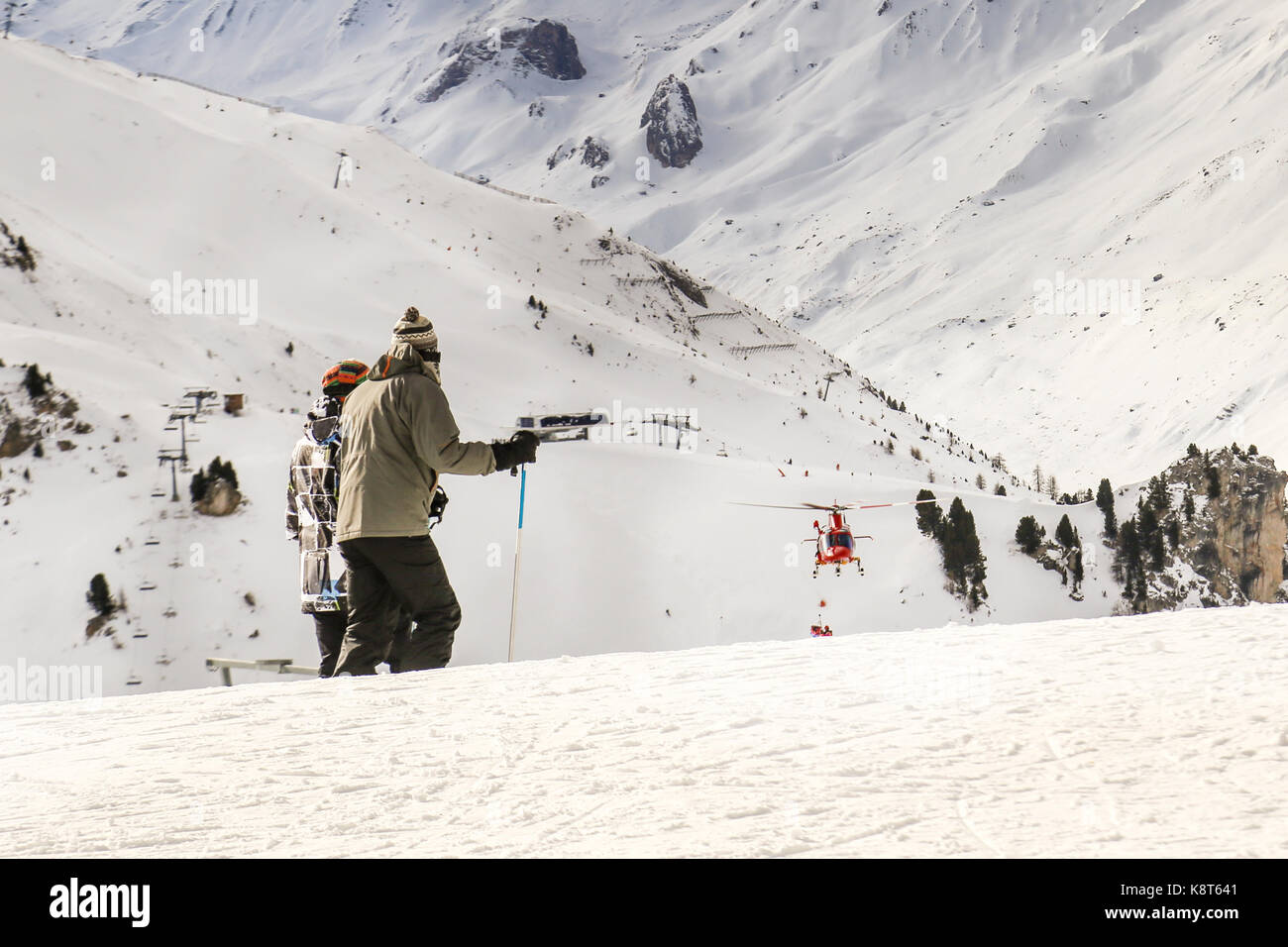 People watching how rescue helicopter evacuates skier after accident