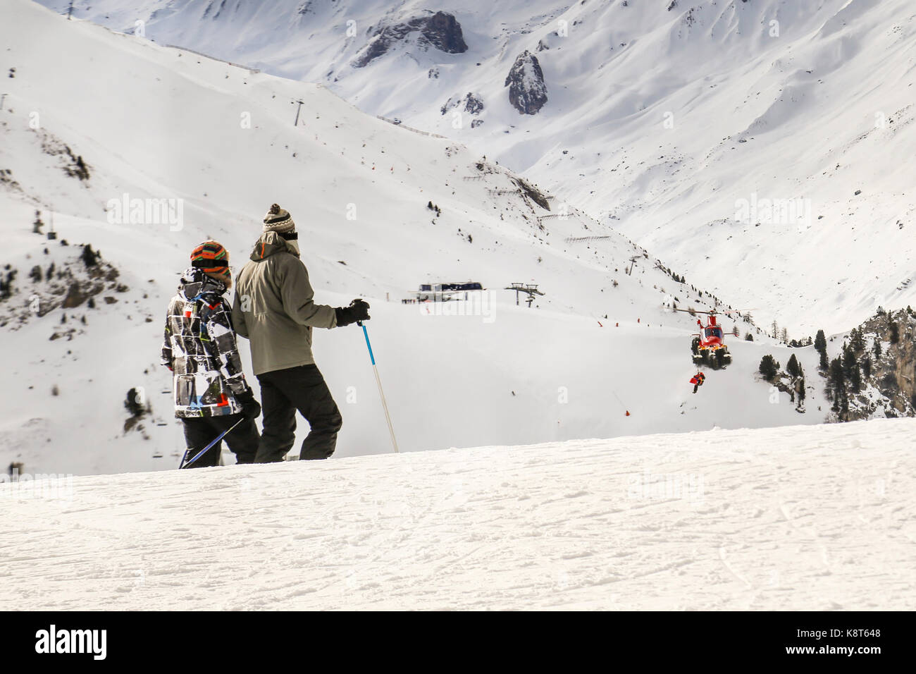People watching how rescue helicopter evacuates skier after accident