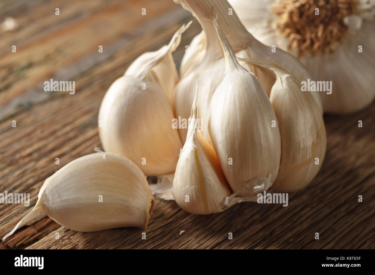 Garlic bulbs and cloves on a old wooden background Stock Photo - Alamy