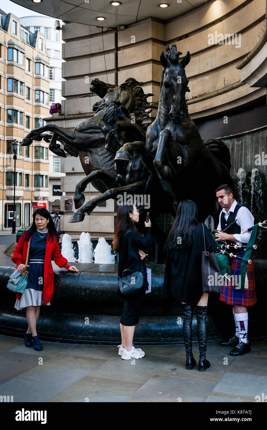 Female Tourists Chatting With A Street Entertainer, Piccadilly Circus, London, UK Stock Photo