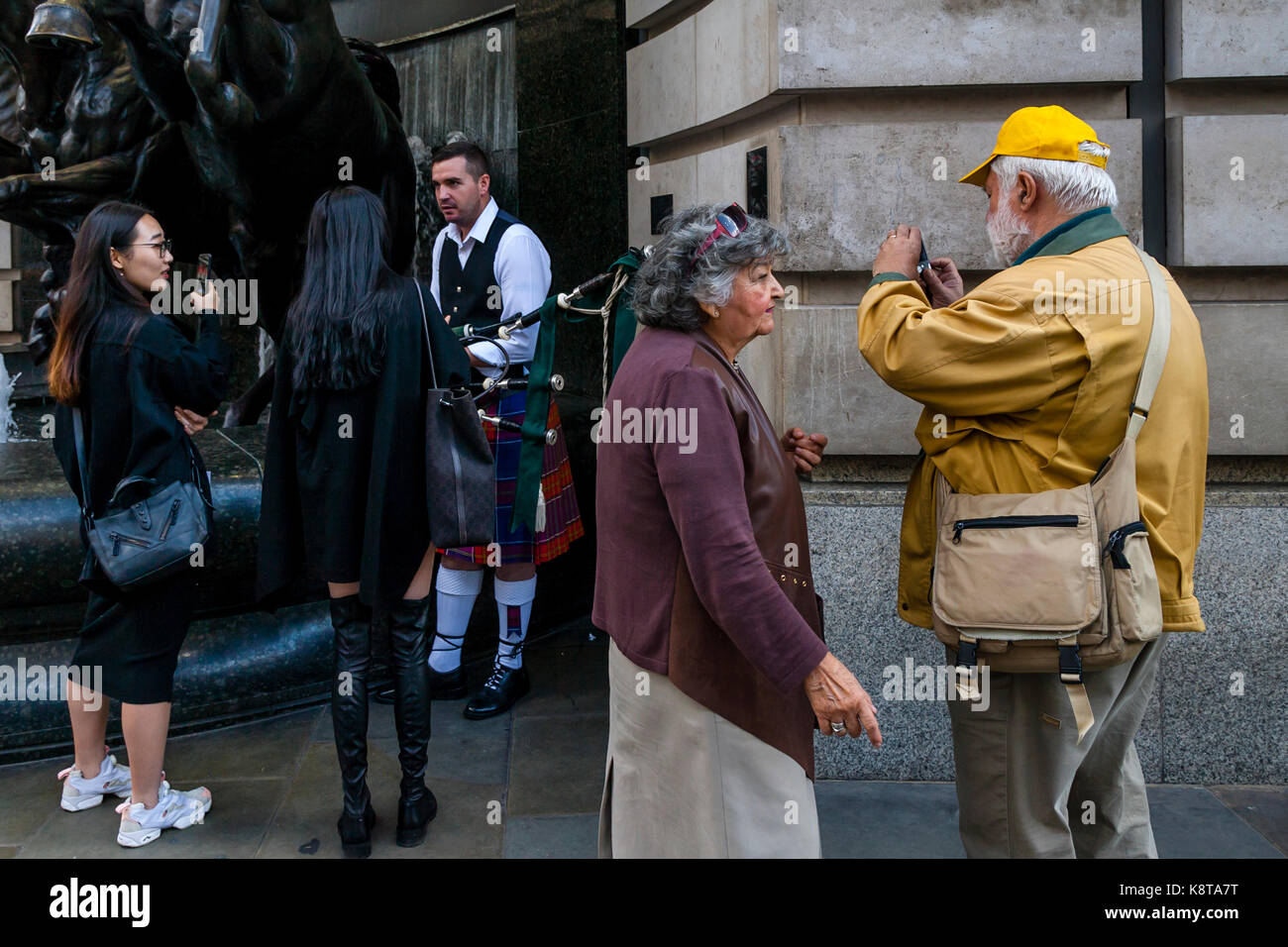 Female Tourists Chatting With A Street Entertainer, Piccadilly Circus, London, UK Stock Photo