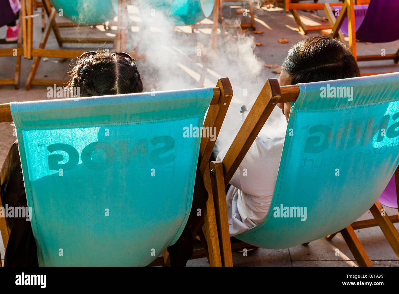 Two People Relaxing On The South Bank, London, UK Stock Photo