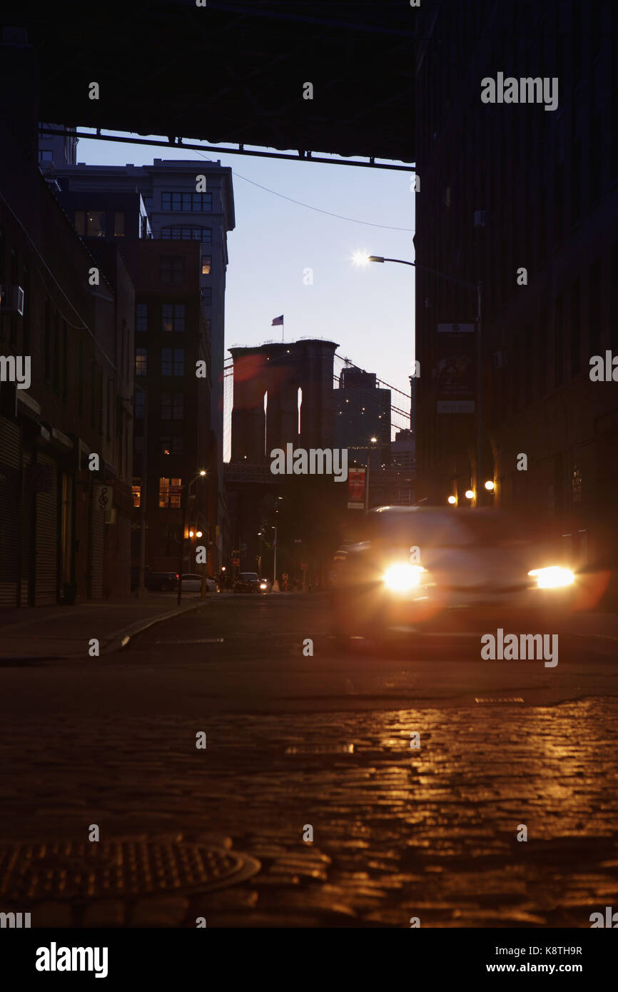 Lens flare car headlights under the Manhattan and Brooklyn Bridge at