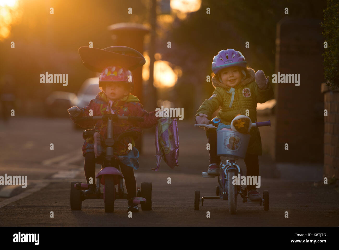 Two young girls pose on their bikes in the setting sun. credit LEE RAMSDEN / ALAMY Stock Photo
