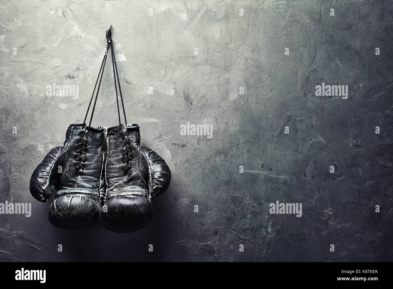 old boxing gloves hang on nail on texture wall with copy space for text.  Retirement concept Stock Photo - Alamy