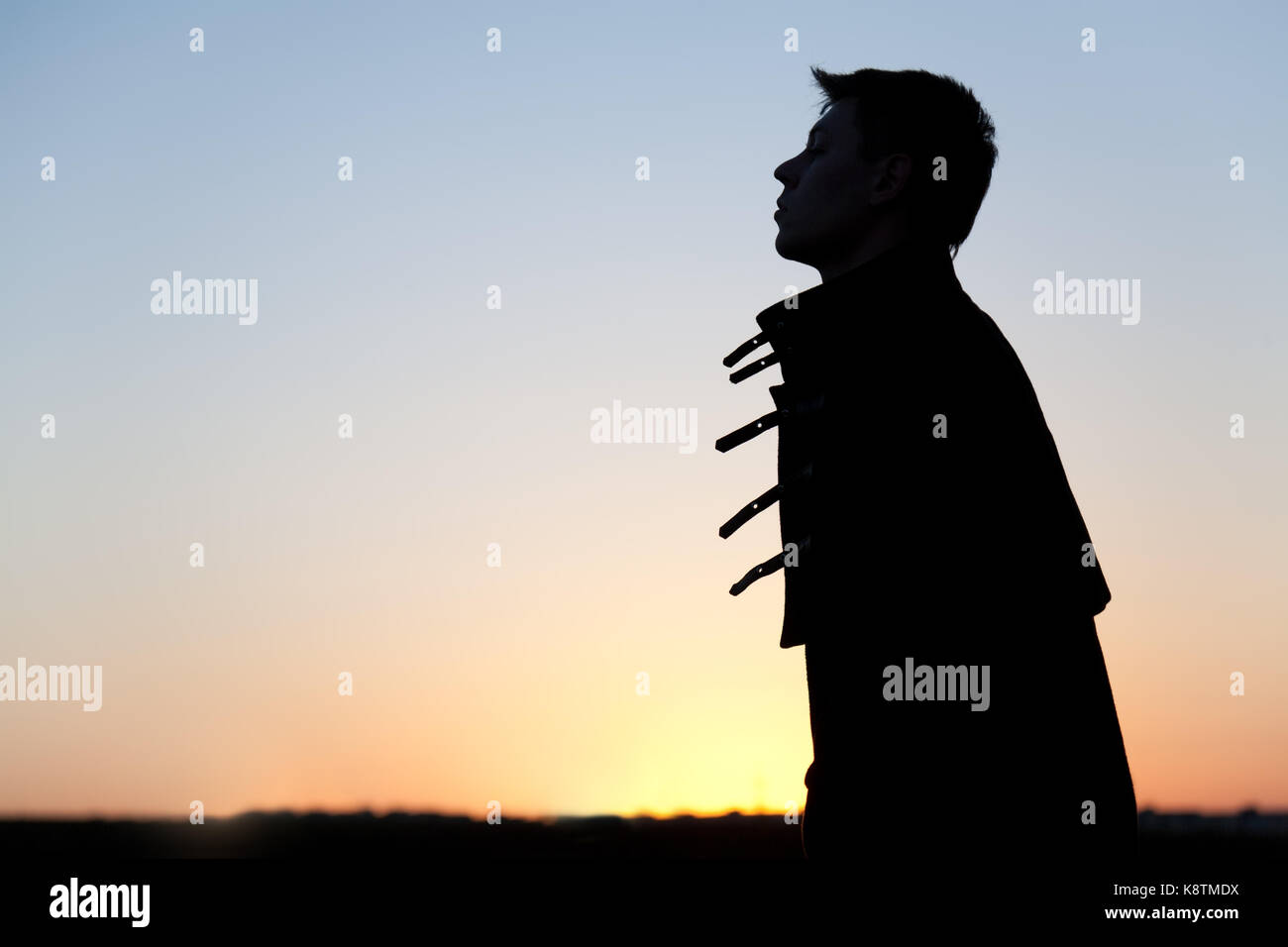 Silhouette of young man at sunset Stock Photo - Alamy