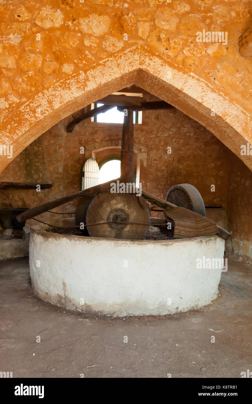 Traditional Greek olive oil stone press with a millstone. Crete, Greece Stock Photo