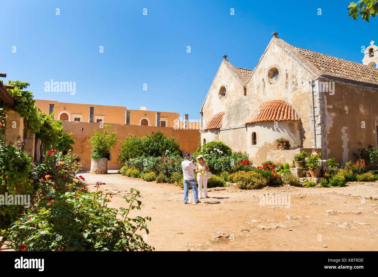 Couple taking a photo in the inner garden of the Arkadi Monastery. Arkadi, Crete, Greece Stock Photo