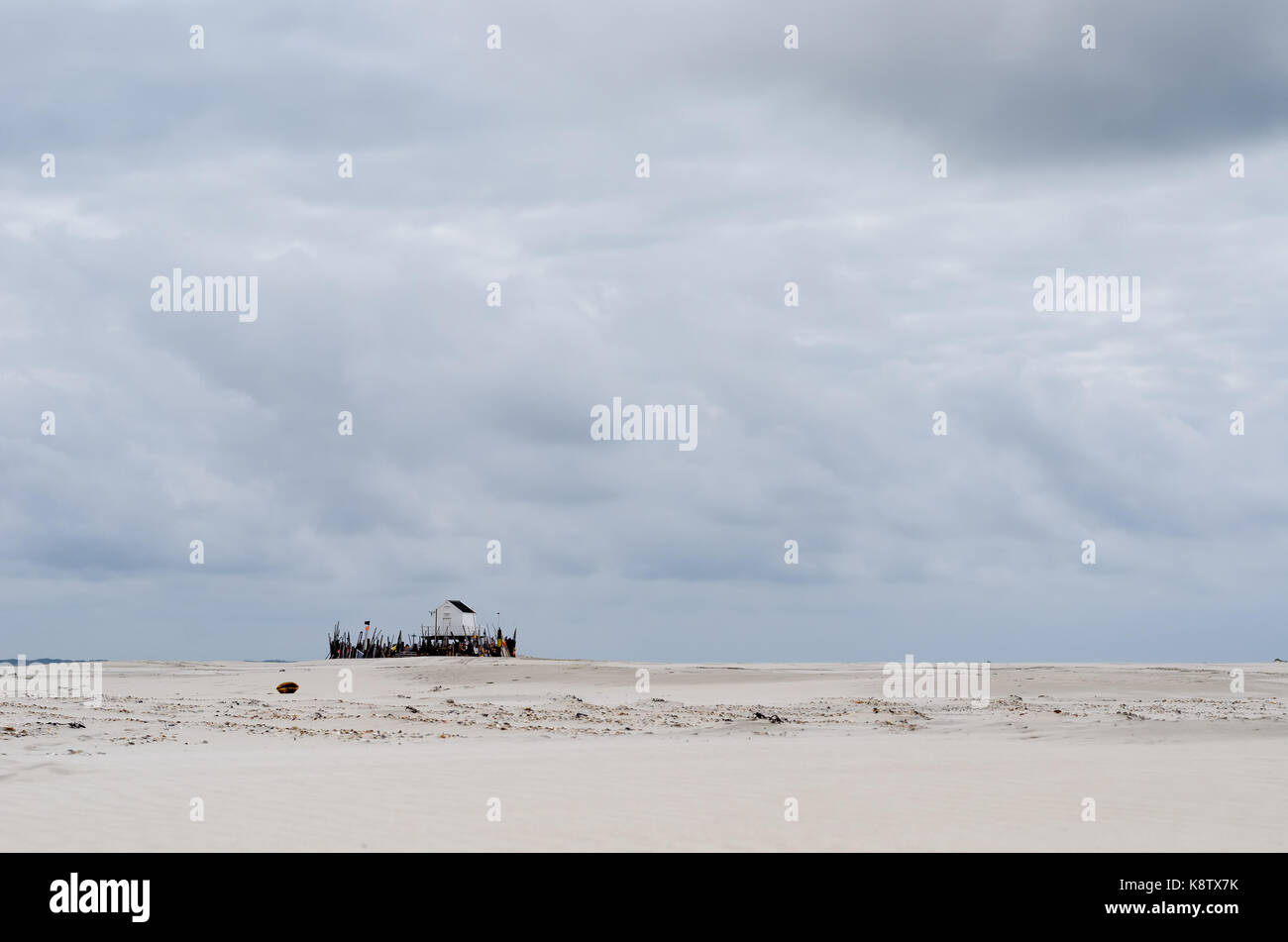 beachcomber house on a wide and lonely beach on a cloudy day Stock Photo