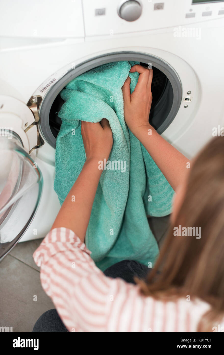 House cleaning. Woman putting towel in washing machine Stock Photo Alamy
