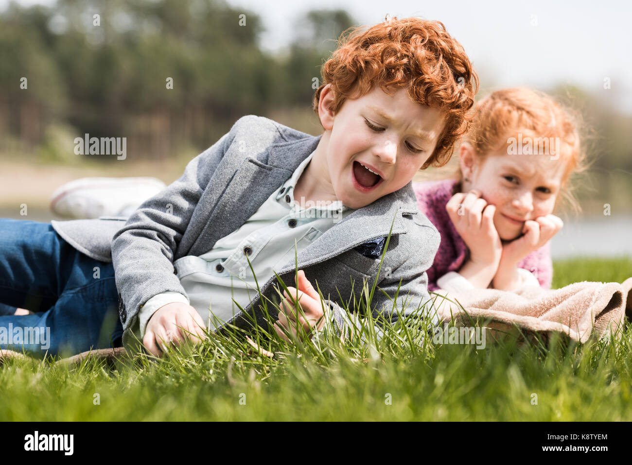 siblings lying on grass  Stock Photo