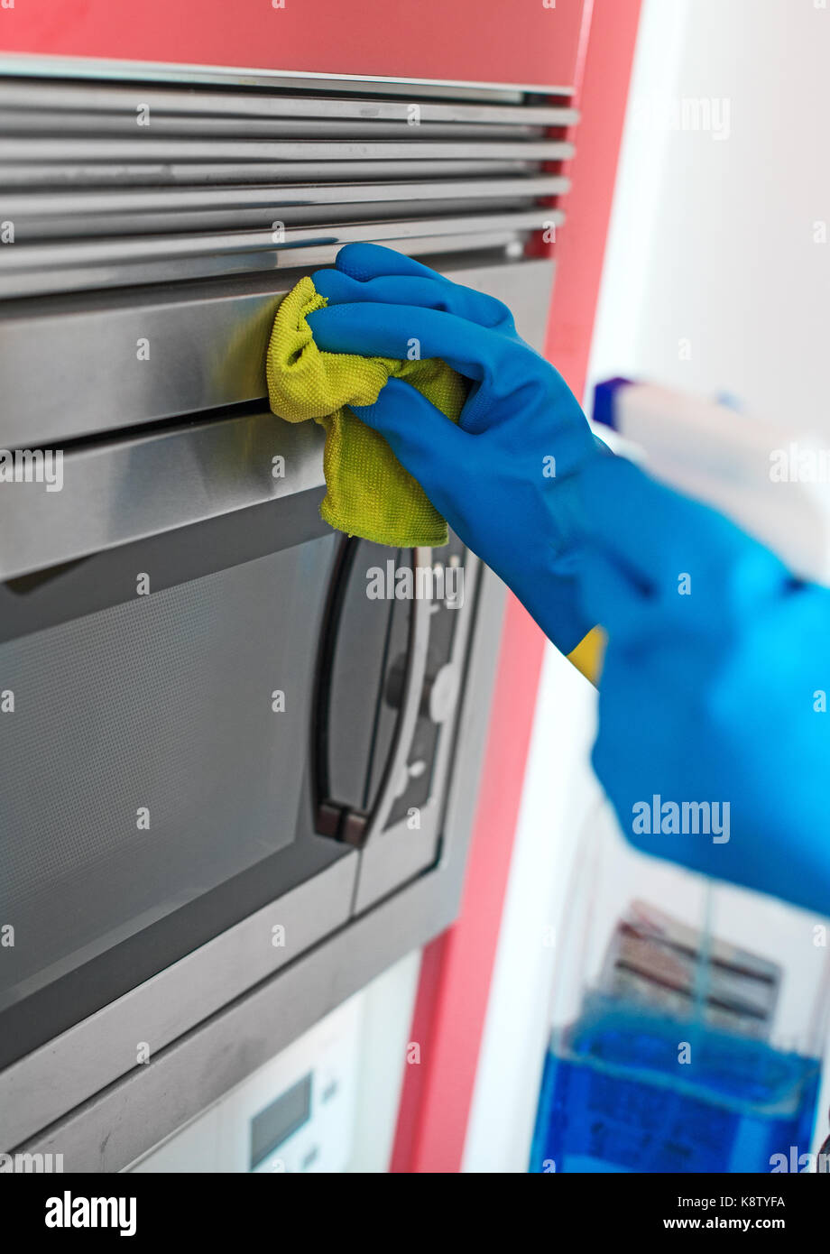 House cleaning. Woman is wiping microwave oven. Stock Photo