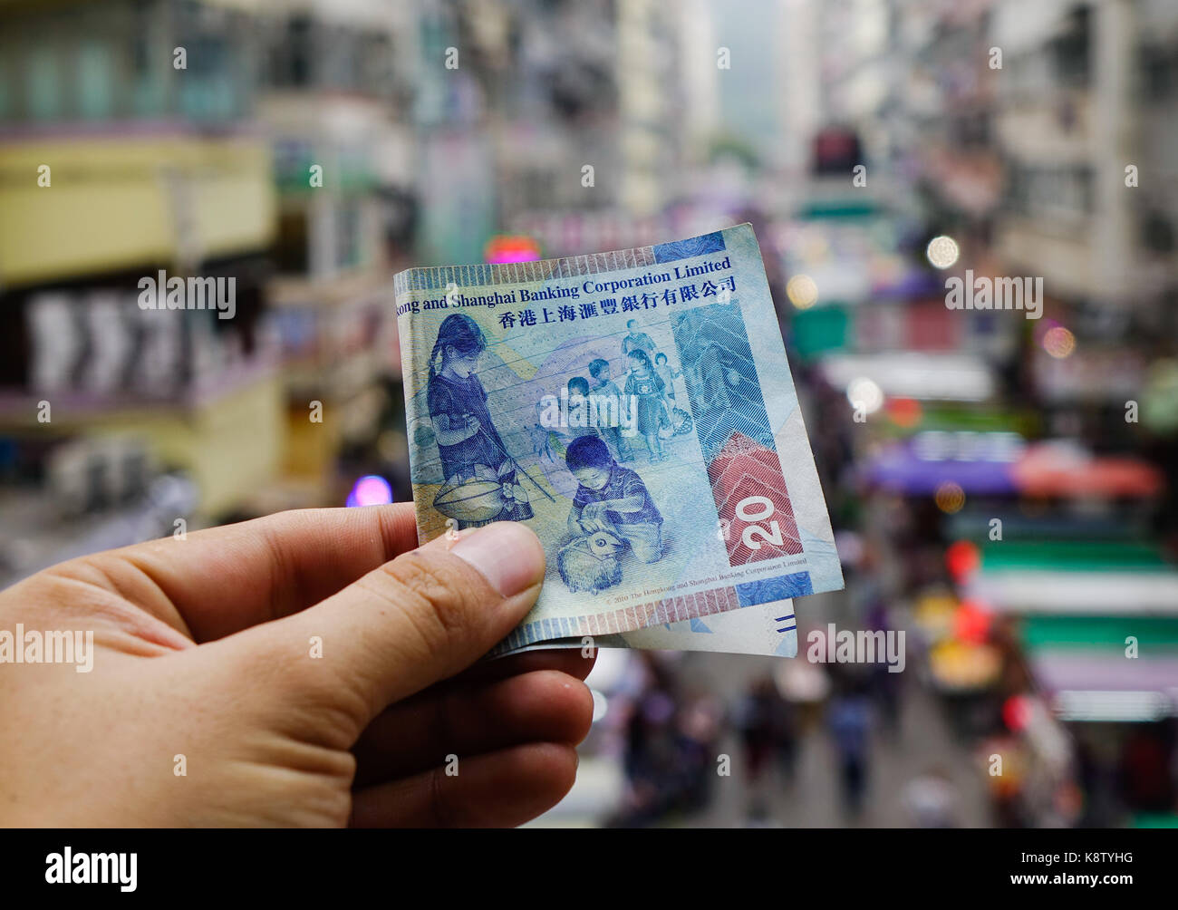 Hand holding Hong Kong dollar (HKD) billnotes with cityscape background  Stock Photo - Alamy