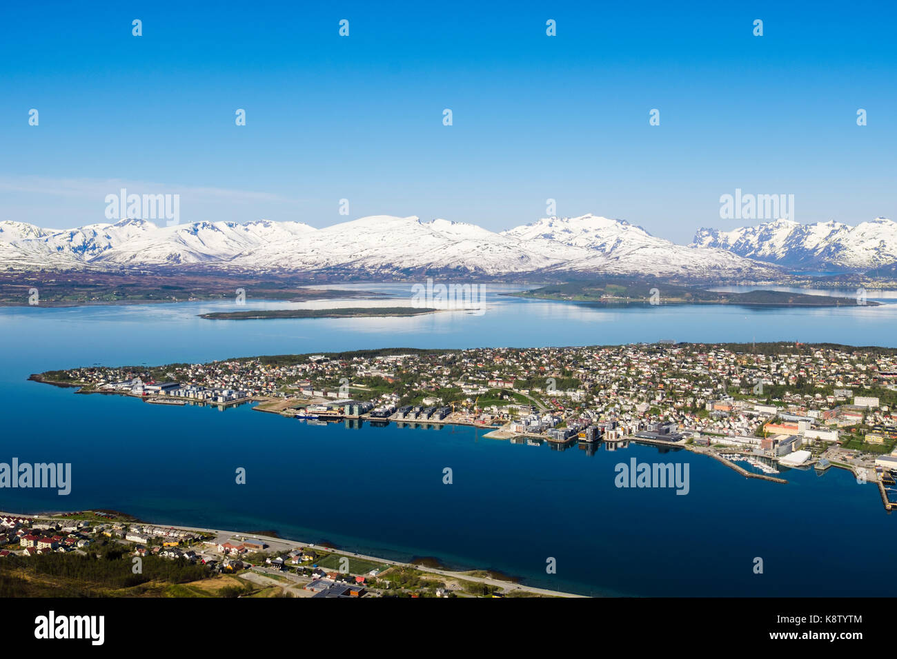High view above old city on Tromsoya island with snow-capped mountains seen from Mount Storsteinen. Tromso, Troms county, Norway, Scandinavia Stock Photo