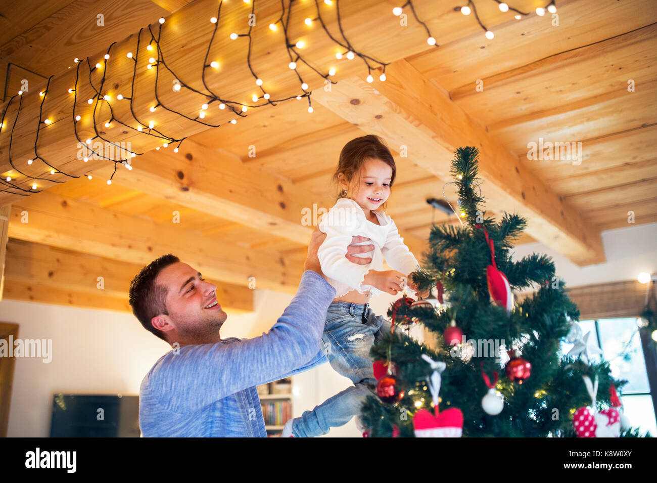 Young father with daugter decorating Christmas tree together Stock ...