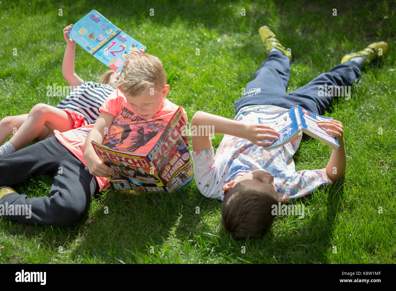kids reading outside Stock Photo