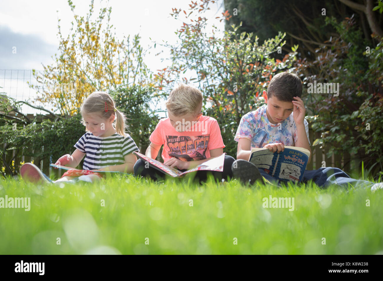 children reading in the garden Stock Photo