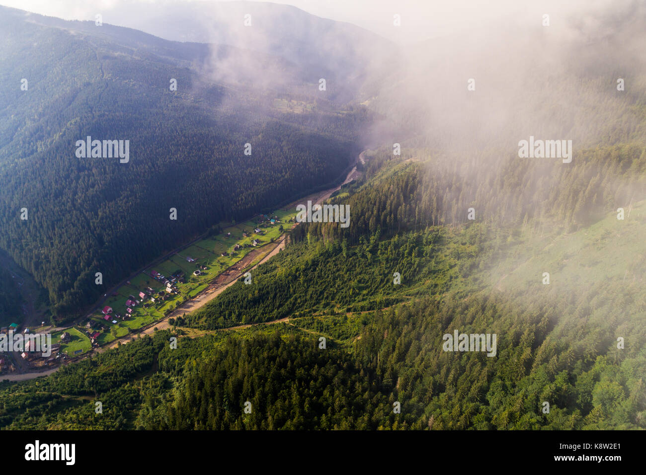 Aerial view of the village in the Carpathian mountains with clouds in ...