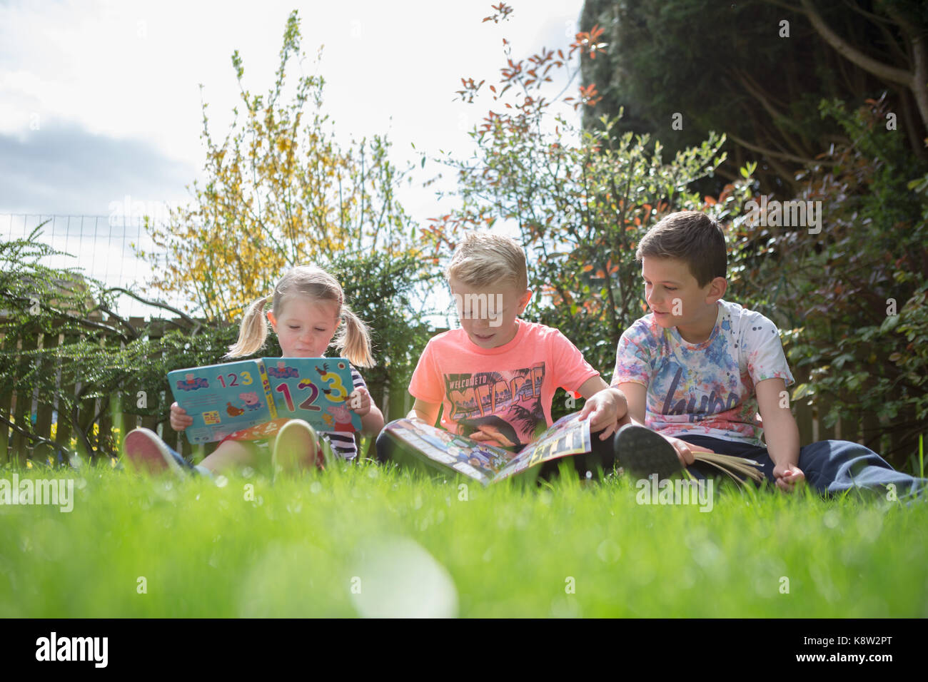 children reading in the garden Stock Photo