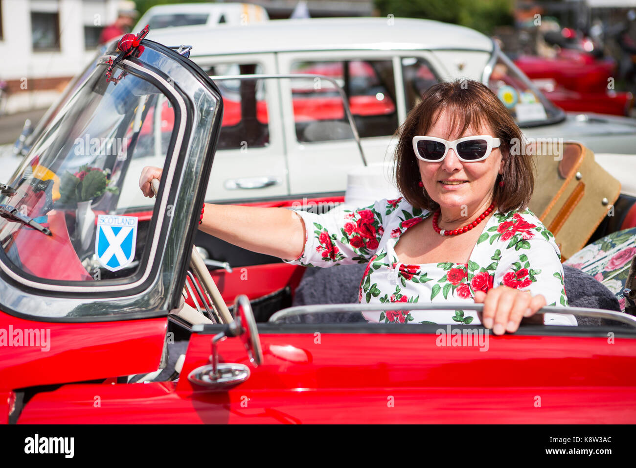 woman in nostalgic outfit is sitting in classic car Skoda Felicia