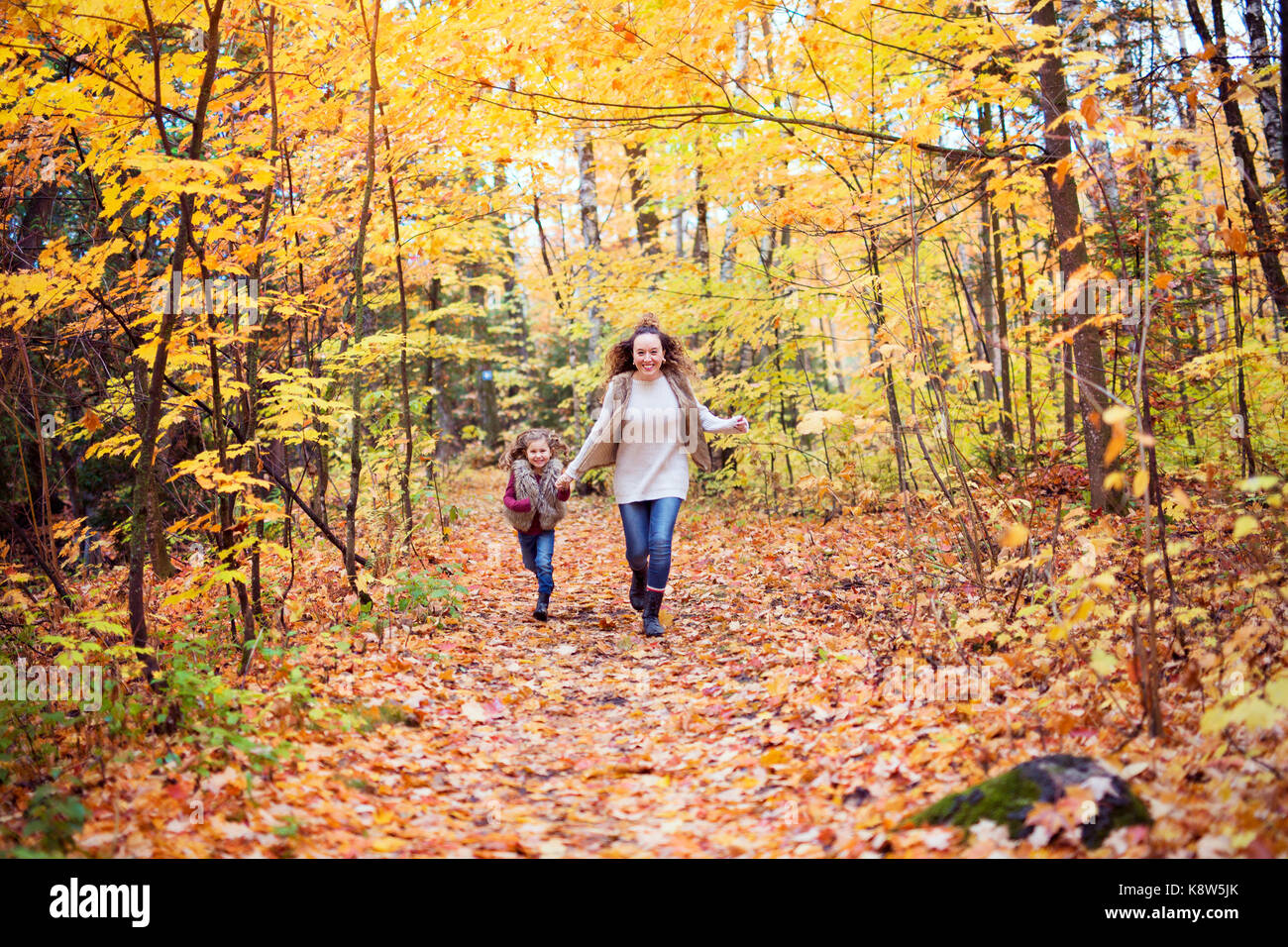 Young mother playing with her daughter in autumn park Stock Photo - Alamy