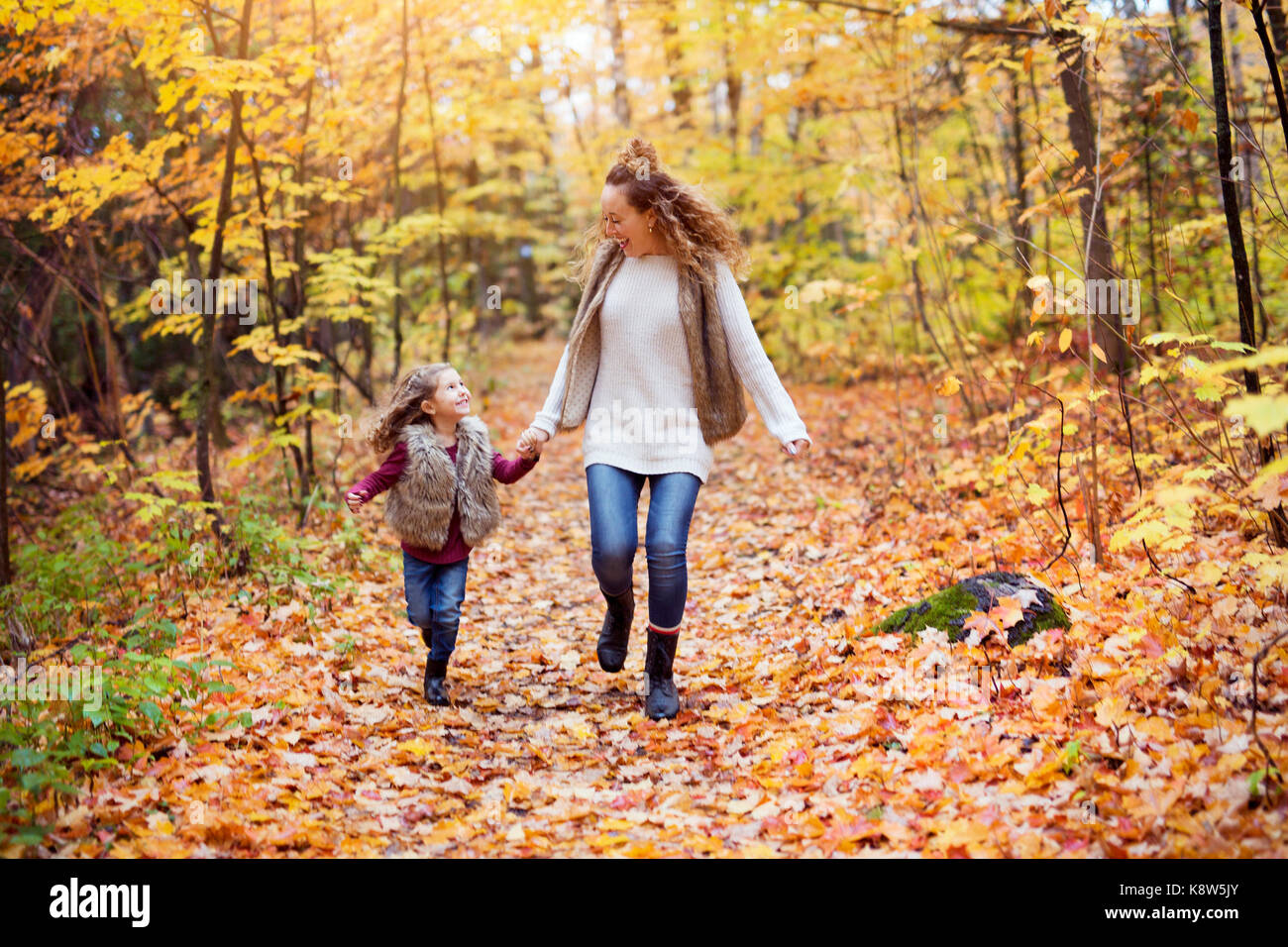 Young mother playing with her daughter in autumn park Stock Photo - Alamy