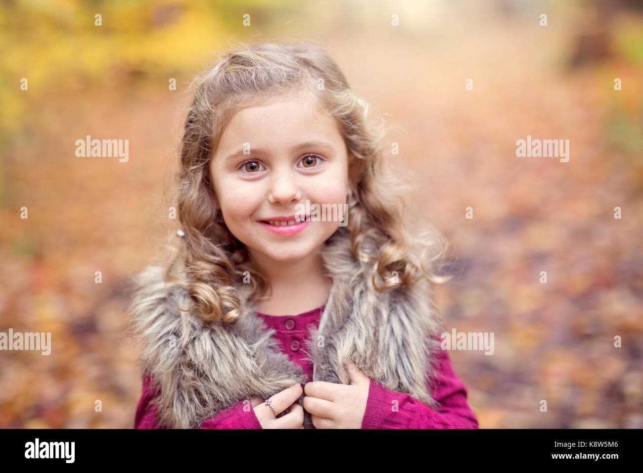 Adorable little girl in a autumn forest Stock Photo - Alamy