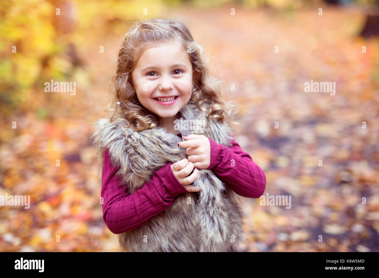 Adorable little girl in a autumn forest Stock Photo - Alamy