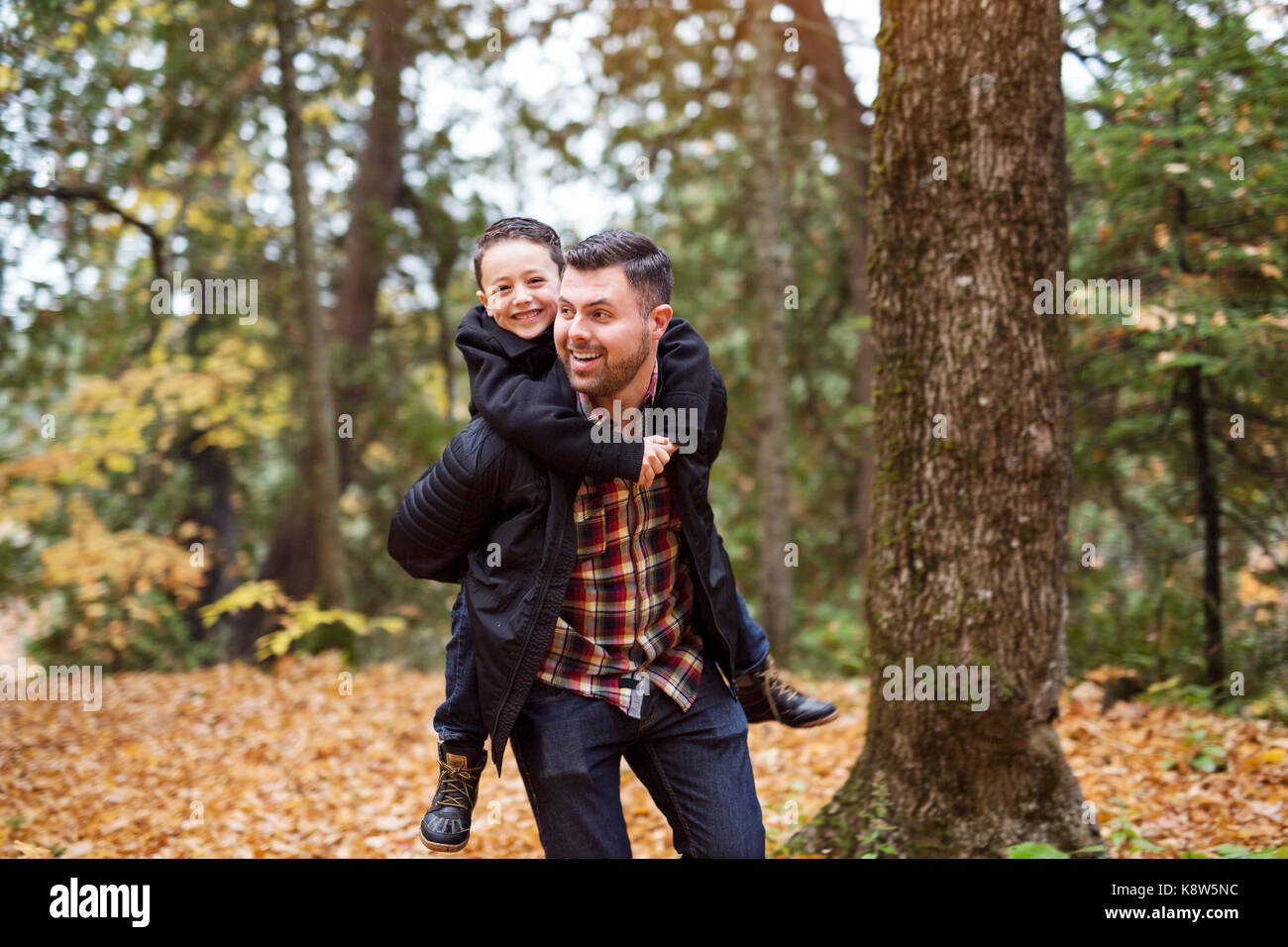 father and son having fun in autumn park Stock Photo - Alamy