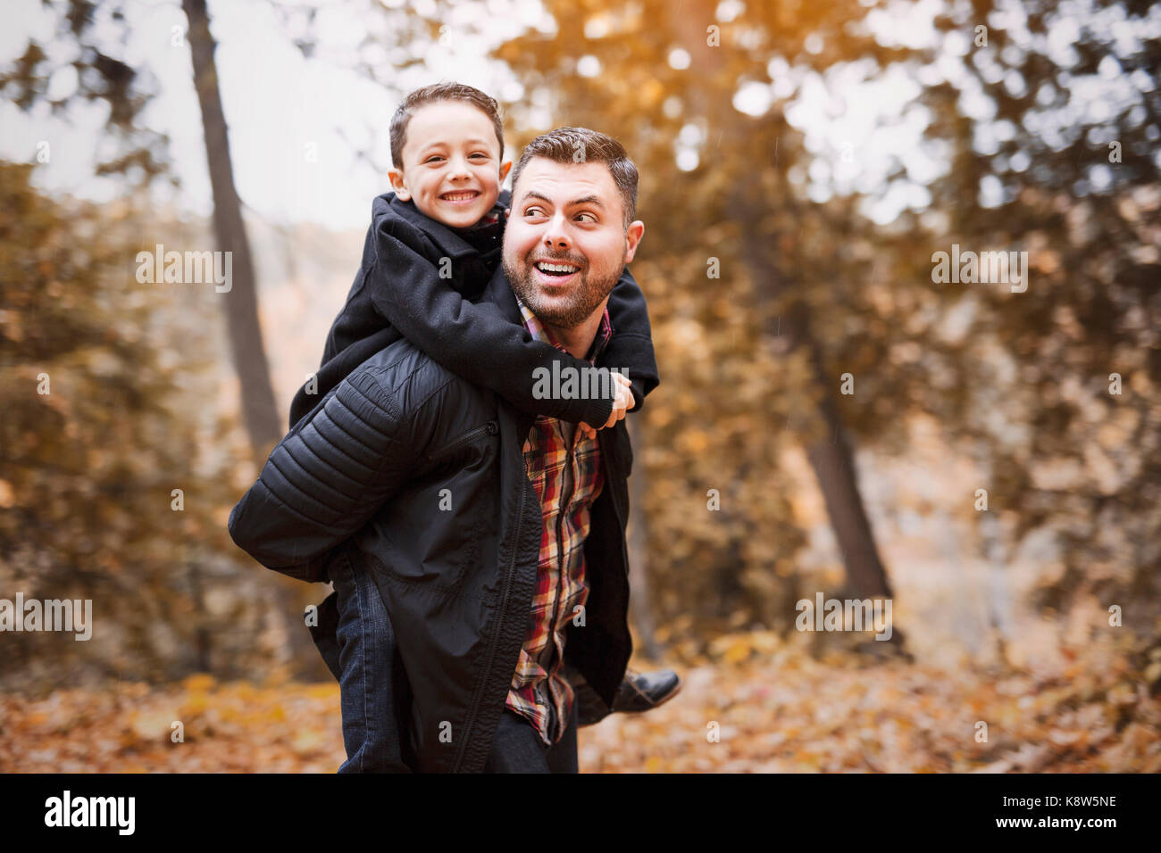 father and son having fun in autumn park Stock Photo - Alamy