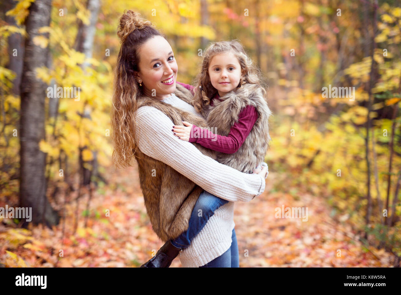 Young mother playing with her daughter in autumn park Stock Photo - Alamy