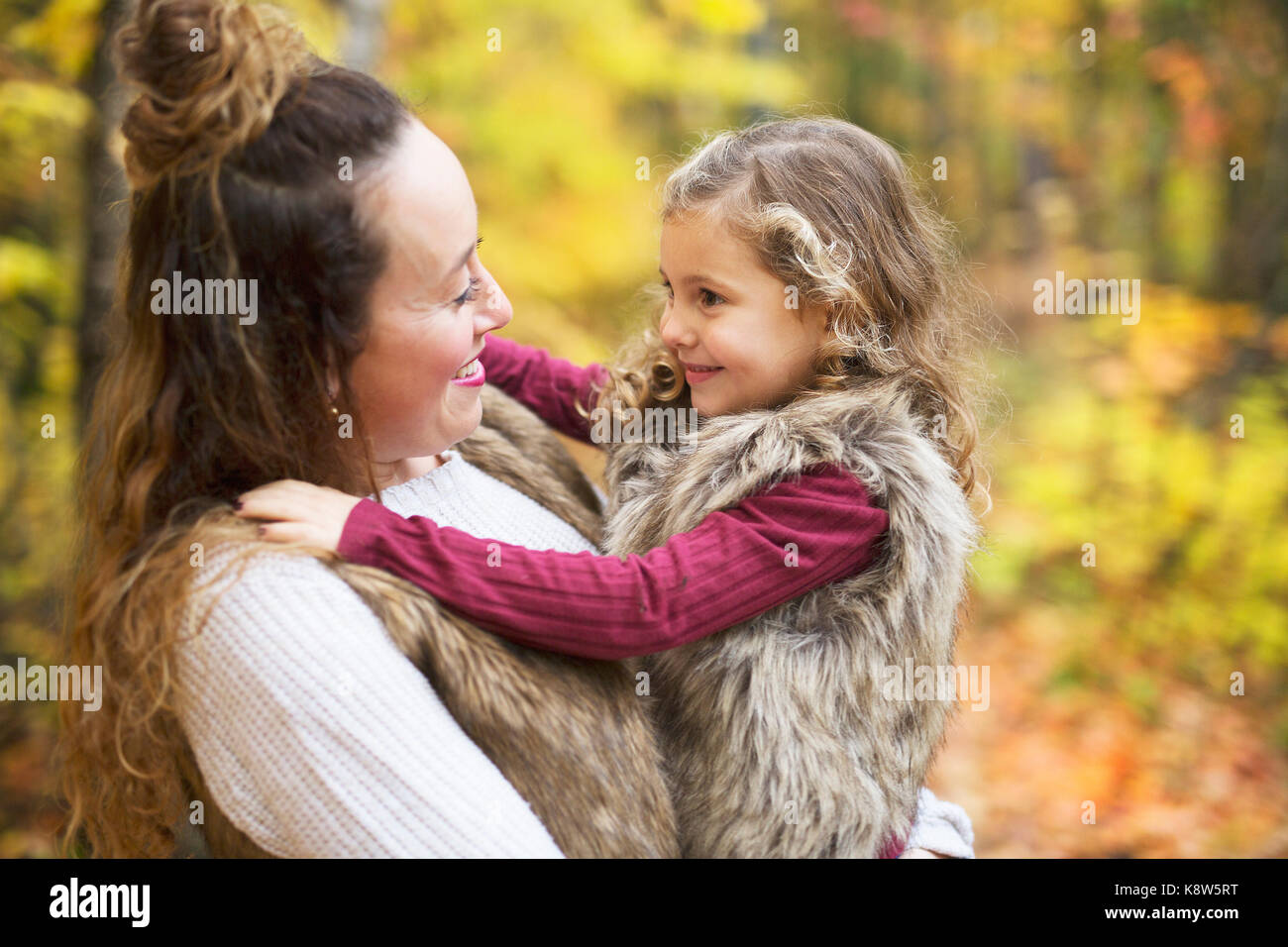 Young mother playing with her daughter in autumn park Stock Photo - Alamy