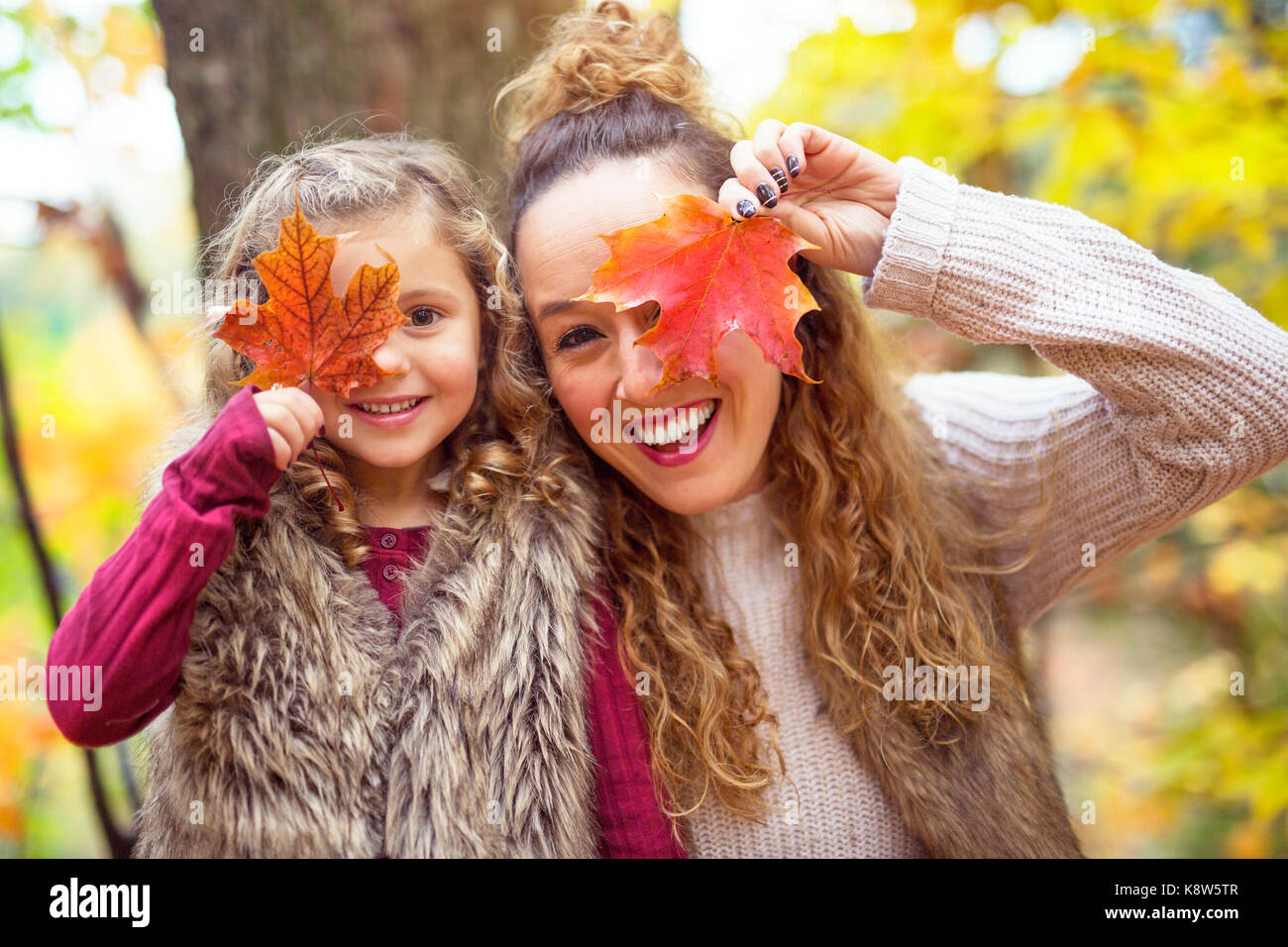 Young mother playing with her daughter in autumn park Stock Photo - Alamy