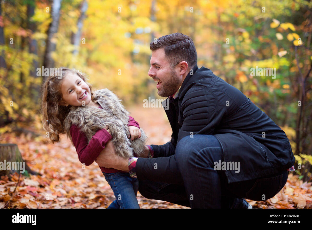 Little adorable girl with happy father in autumn park outdoors Stock Photo