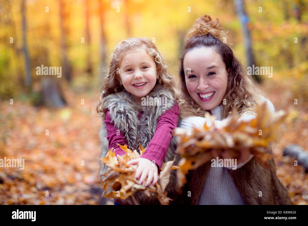 Young mother playing with her daughter in autumn park Stock Photo - Alamy