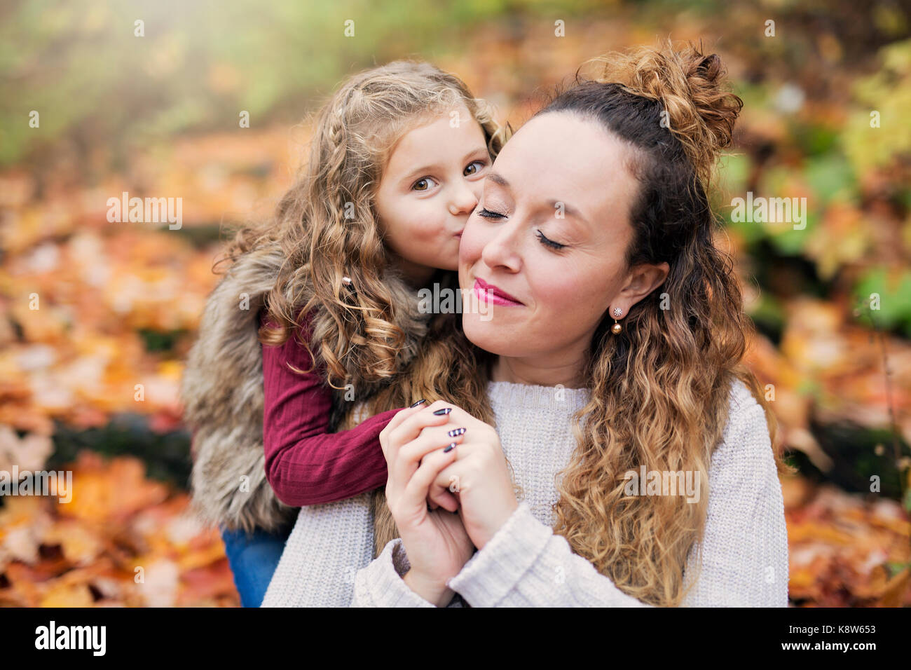 Young mother playing with her daughter in autumn park Stock Photo - Alamy