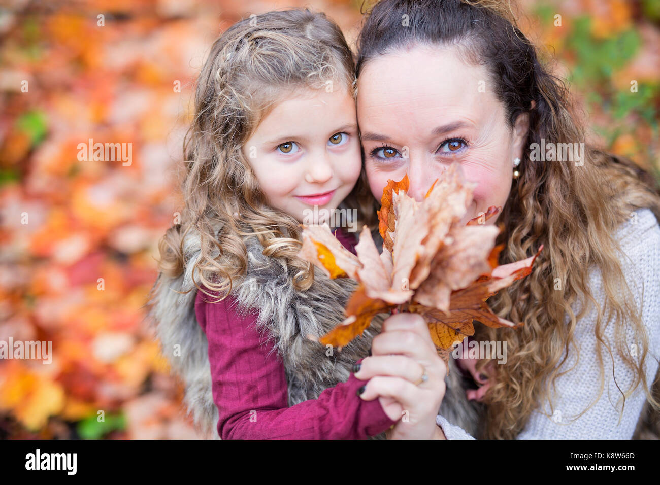 Young mother playing with her daughter in autumn park Stock Photo - Alamy