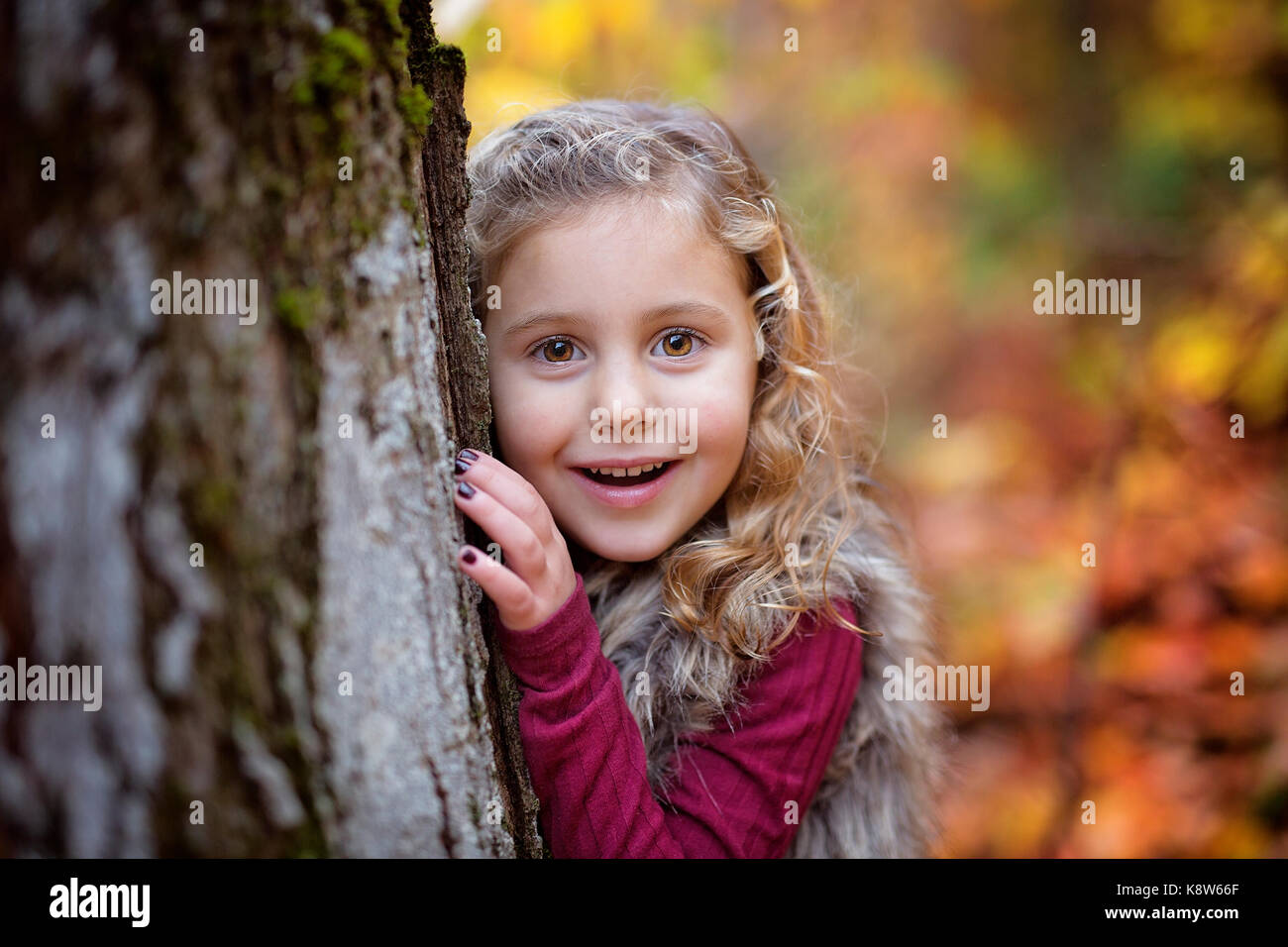 Adorable little girl in a autumn forest Stock Photo - Alamy