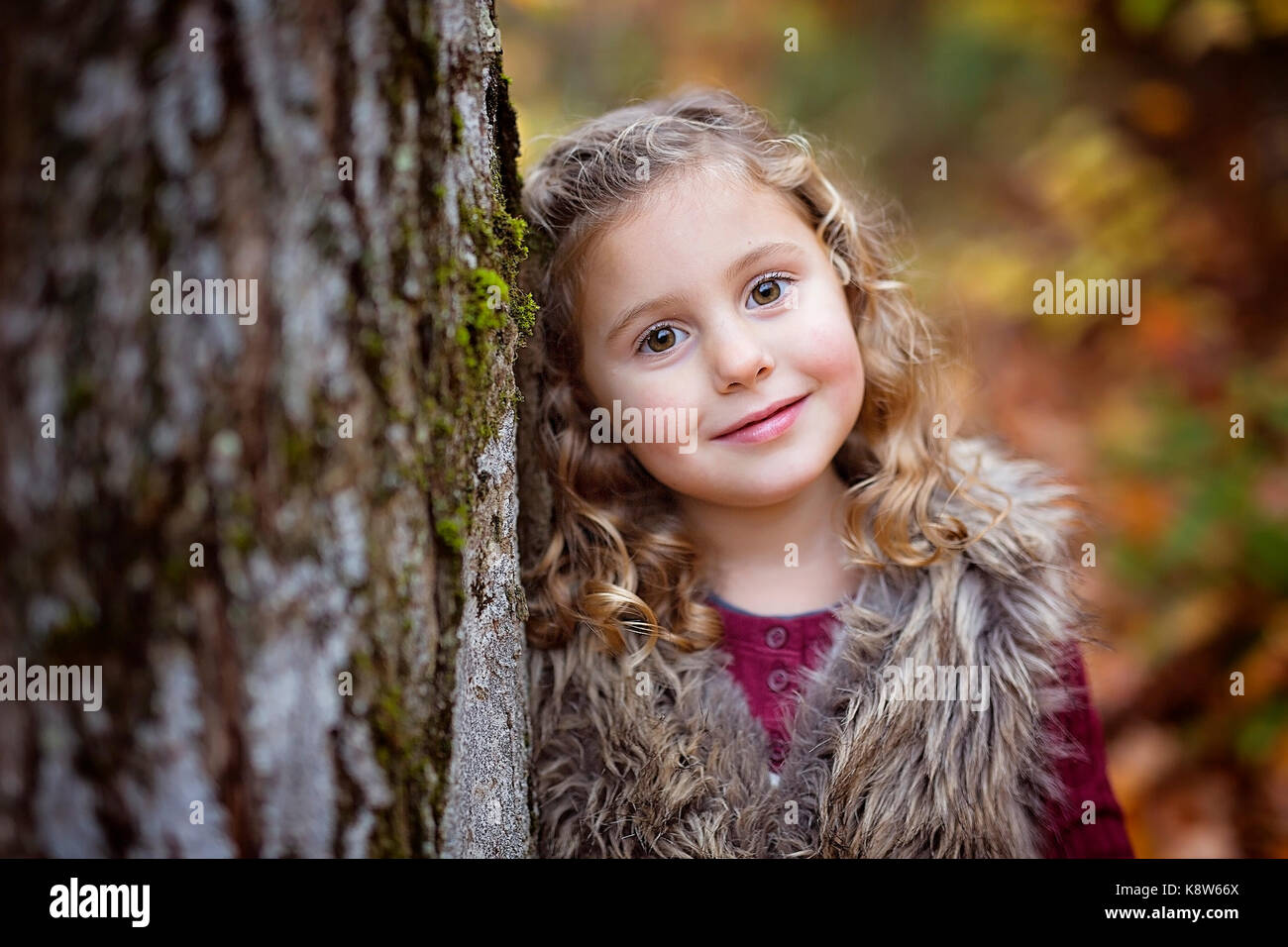 Adorable little girl in a autumn forest Stock Photo - Alamy
