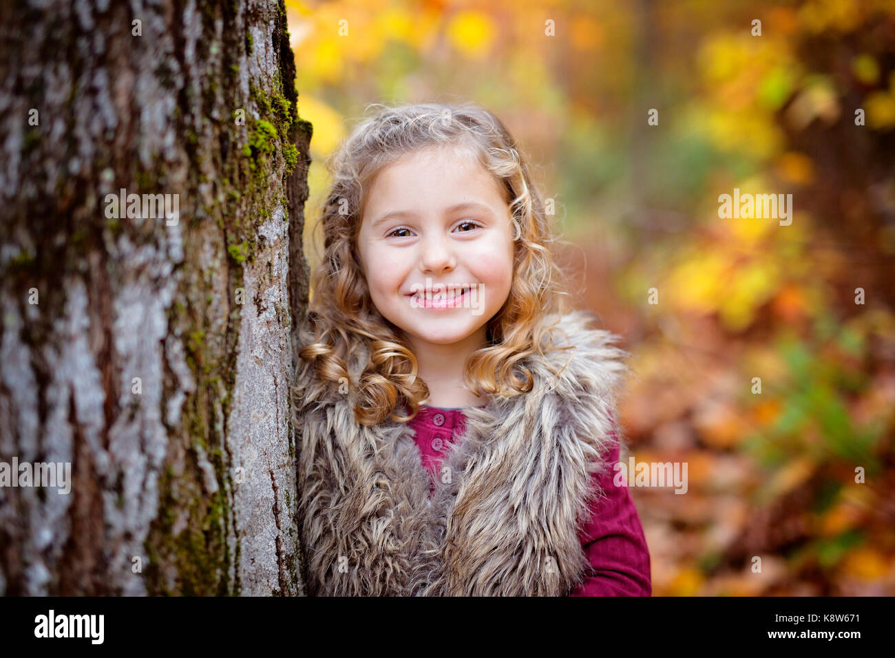 Adorable little girl in a autumn forest Stock Photo - Alamy