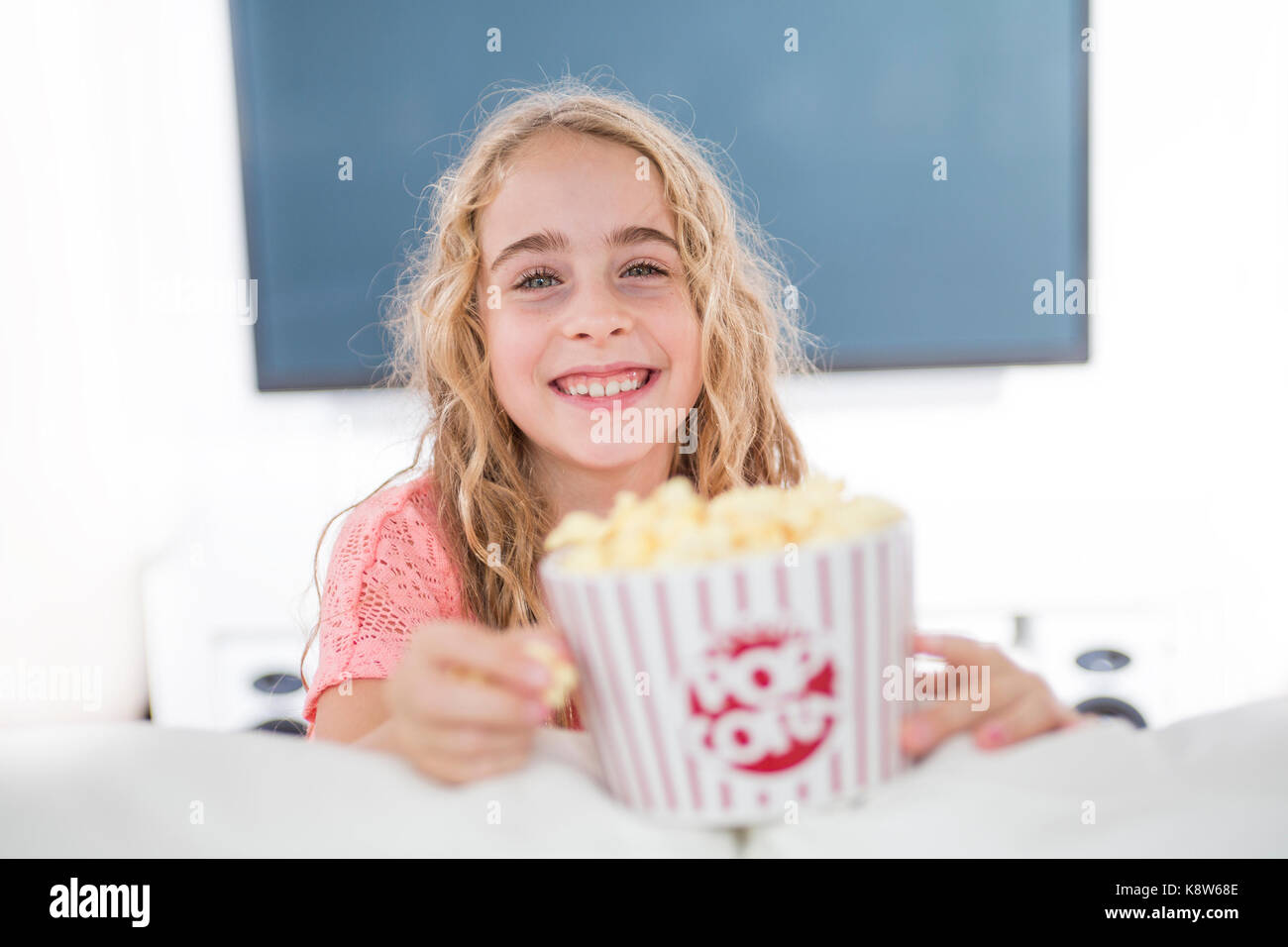 little girl with popcorn in from of tv Stock Photo Alamy