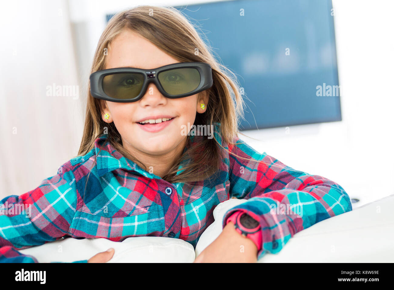 Little girl wearing 3D glasses and watching television Stock Photo Alamy