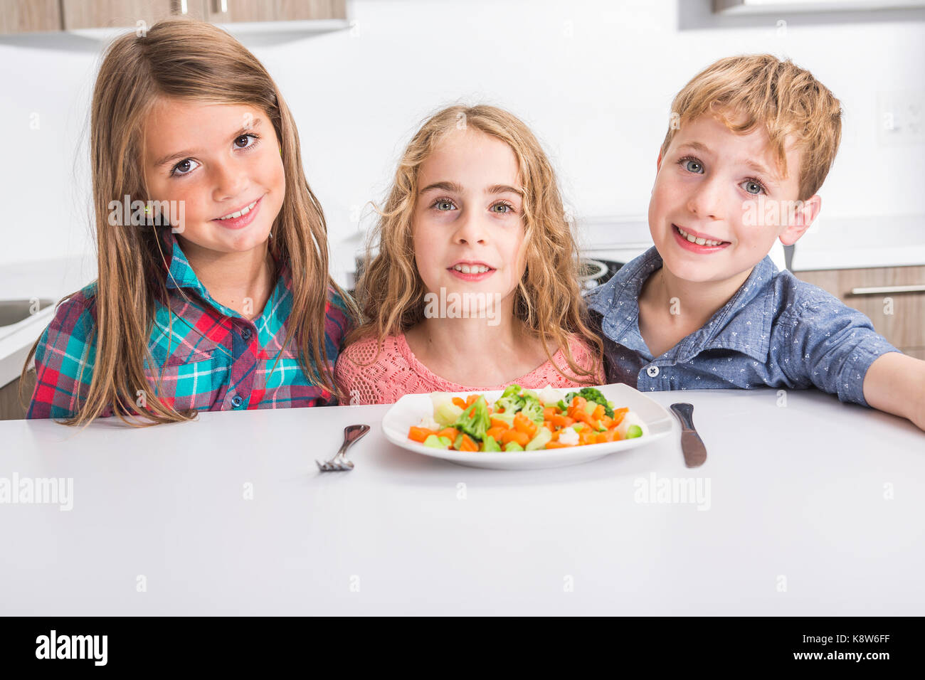 Child eating vegetables isolated in white background Stock Photo - Alamy