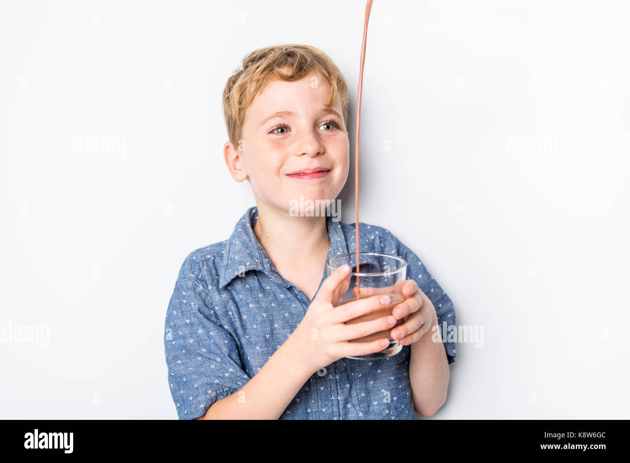 Happy smiling child drinking chocolate milk isolated on white Stock Photo Alamy