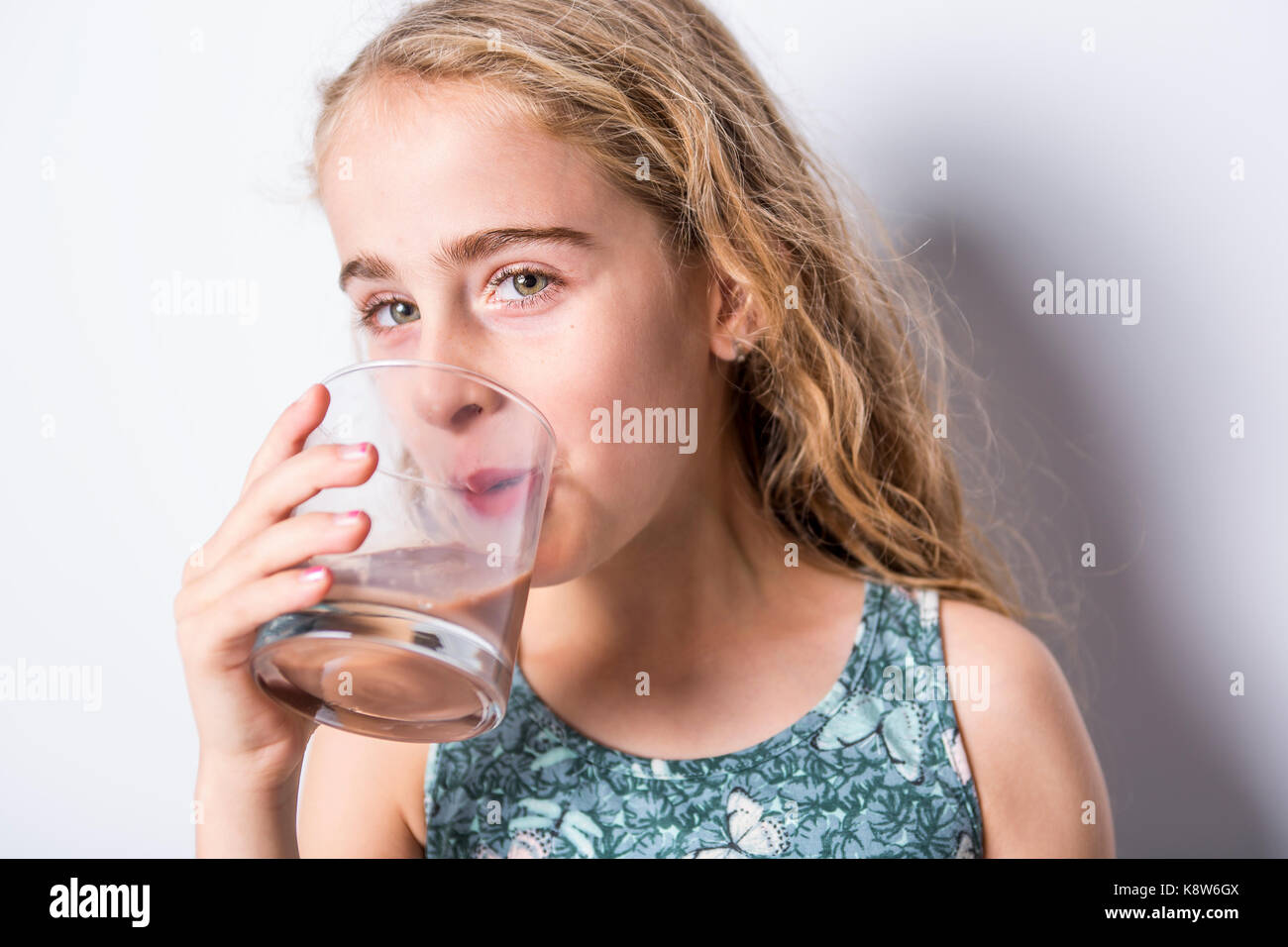 Happy smiling child drinking chocolate milk isolated on white Stock