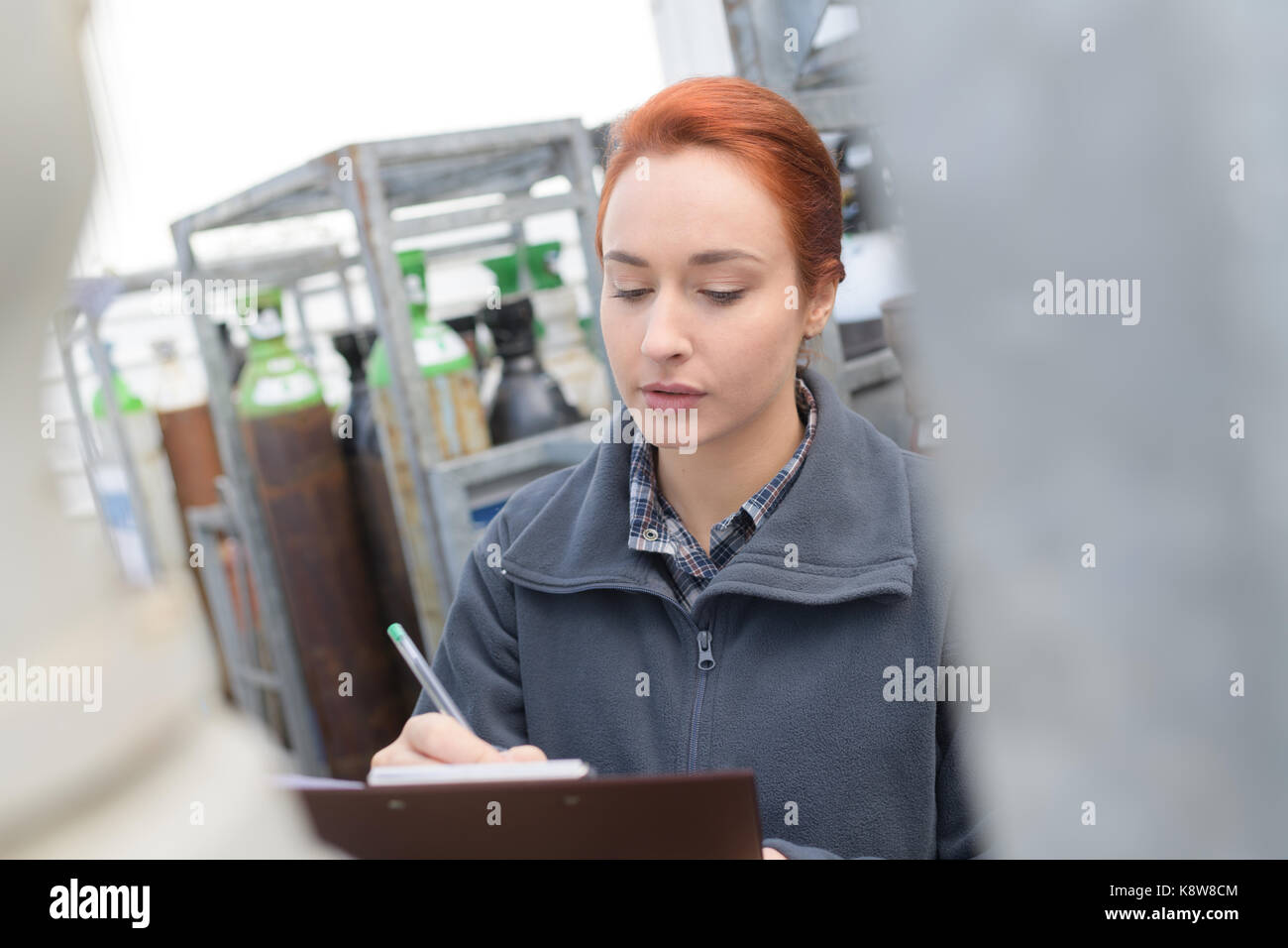 female manager writing on clipboard in warehouse Stock Photo - Alamy