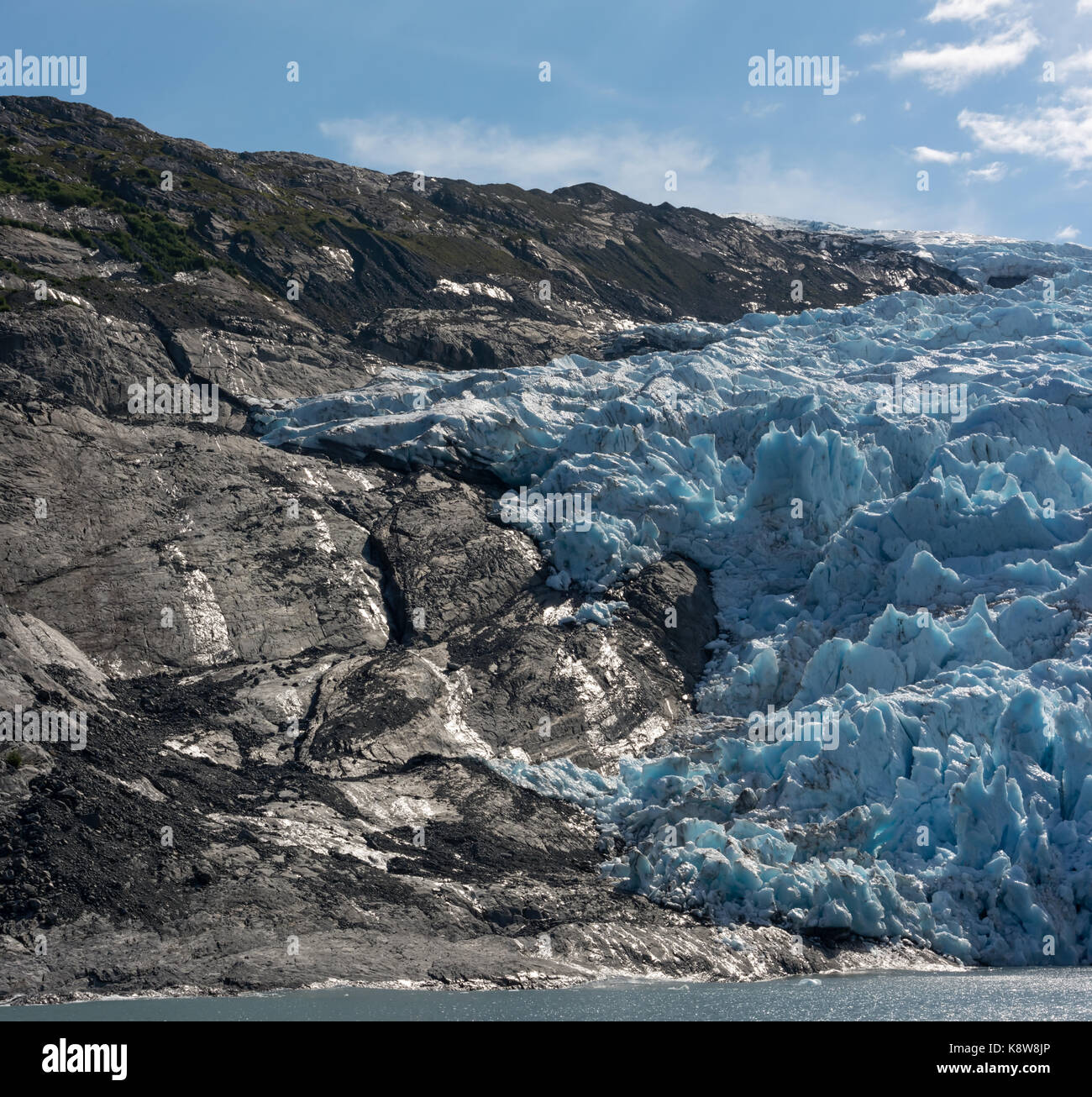 The blue ice of a glacier is a sharp contrast to the dark rock of the