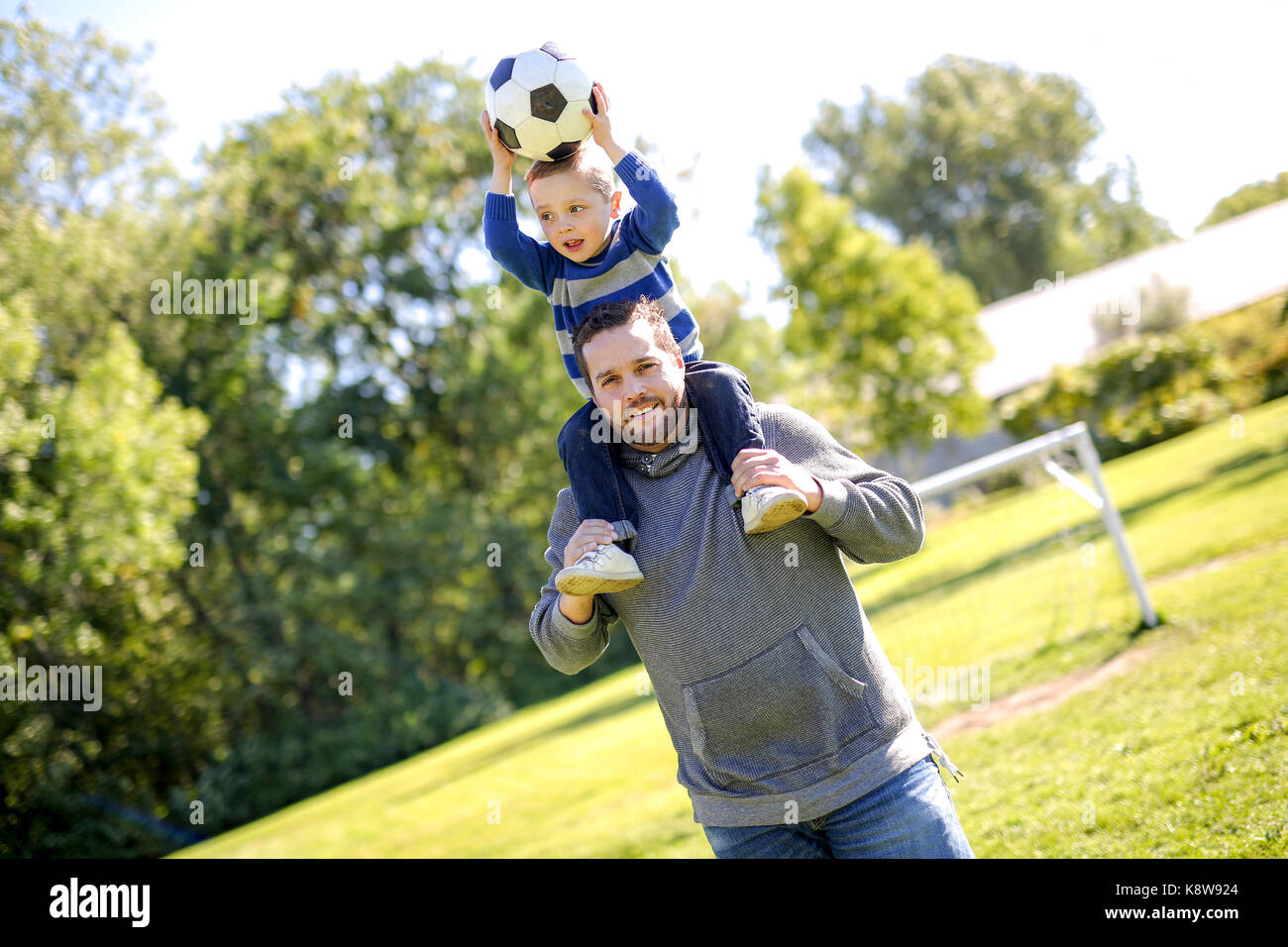 Father and Son Playing Ball in The Park Stock Photo