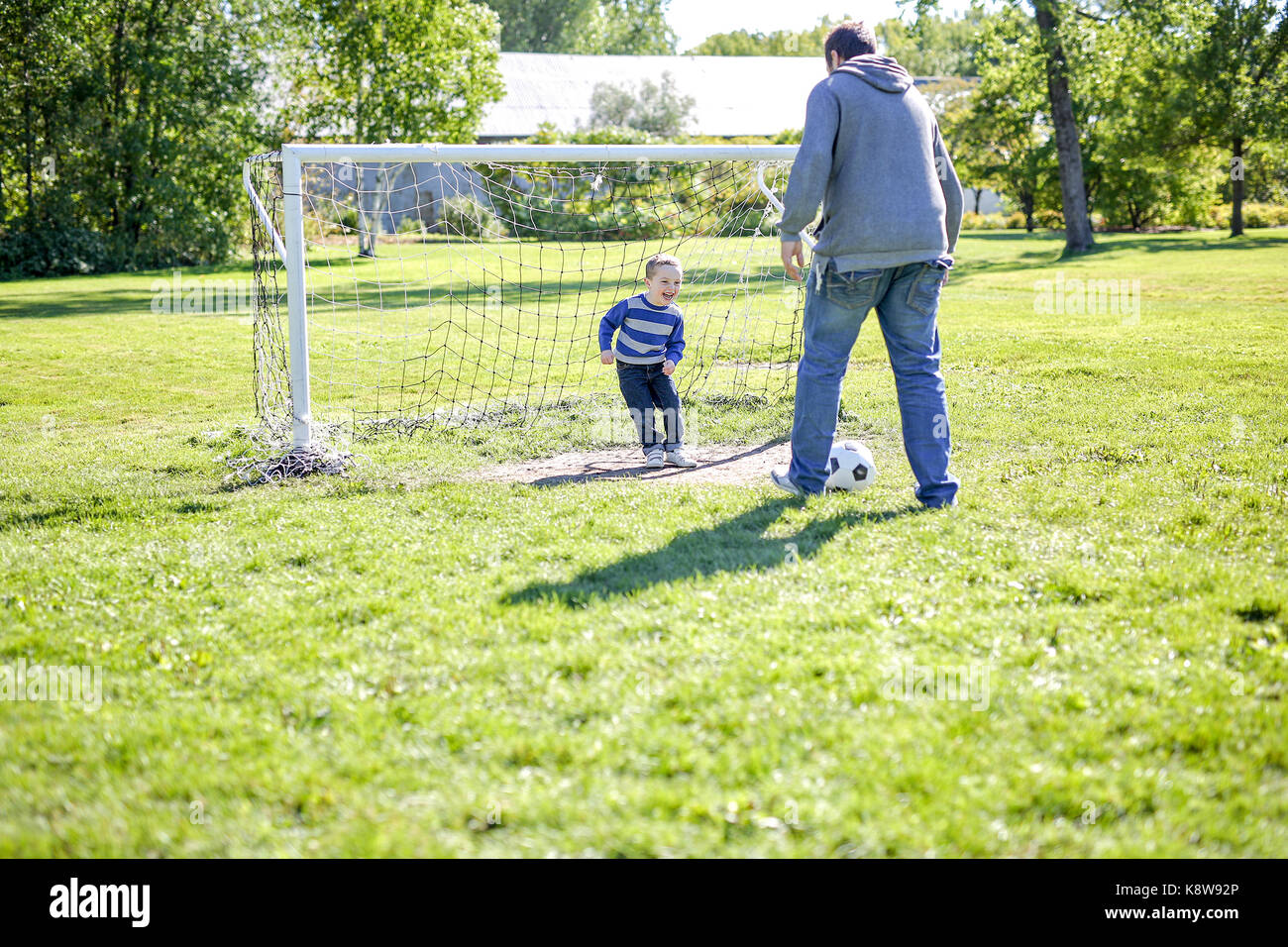 Father and Son Playing Ball in The Park Stock Photo